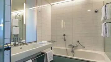 Un bagno moderno con una vasca, un lavandino e uno specchio.