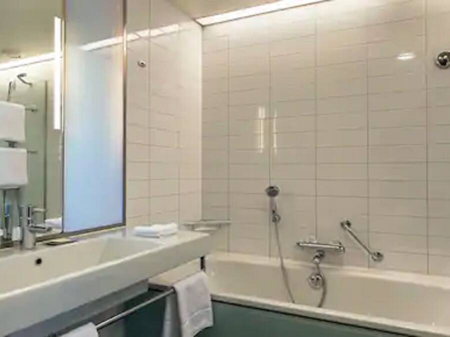 Un bagno moderno con una vasca, un lavandino e uno specchio.