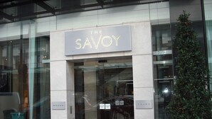 L’entrée d’un immeuble, avec une enseigne indiquant : « THE SAVOY ».