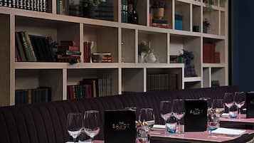 A restaurant with a dark-colored sofa and dining tables set for a meal.
