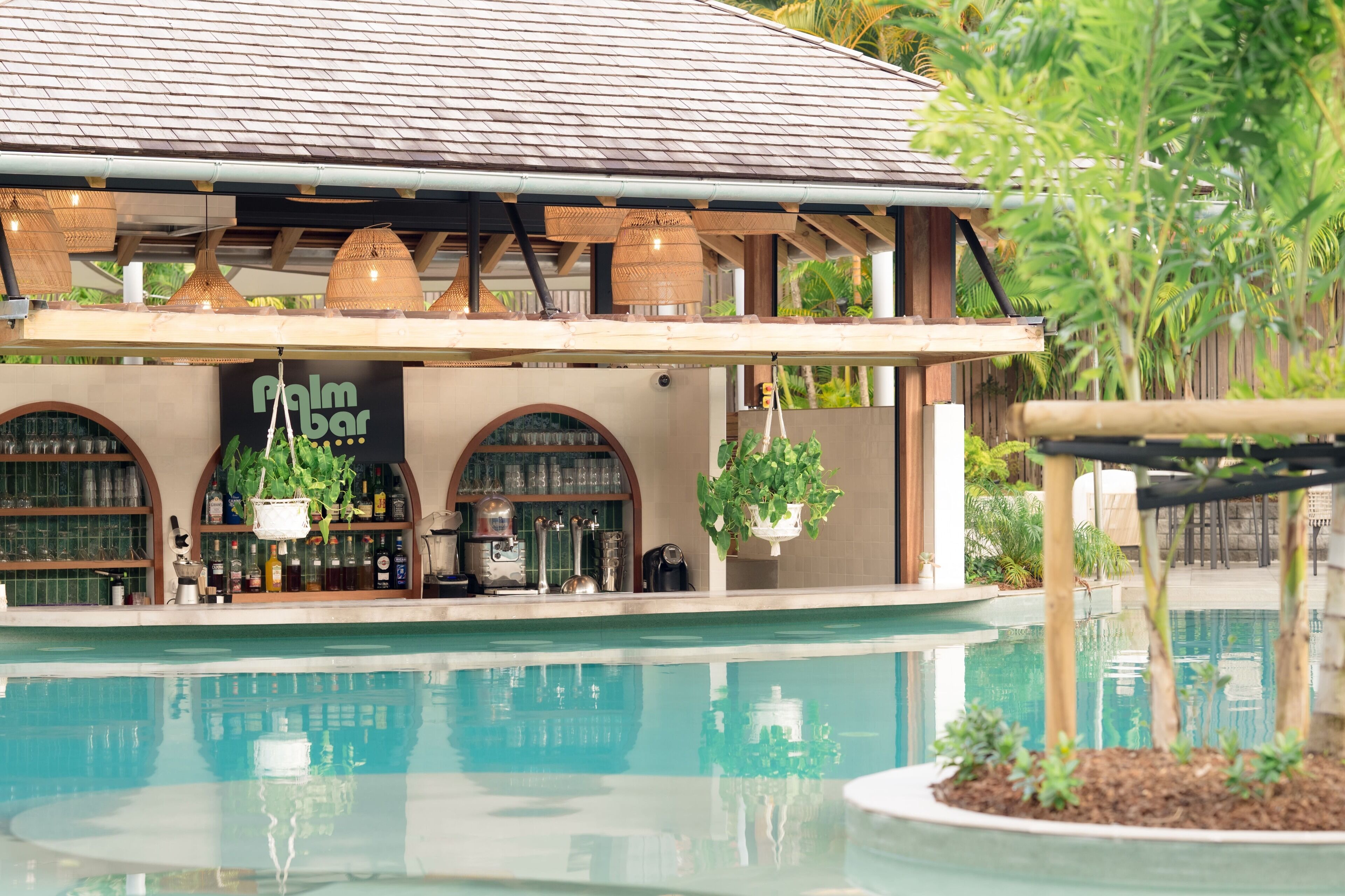 Una piscina al aire libre, sombrillas, sillones reclinables de piscina