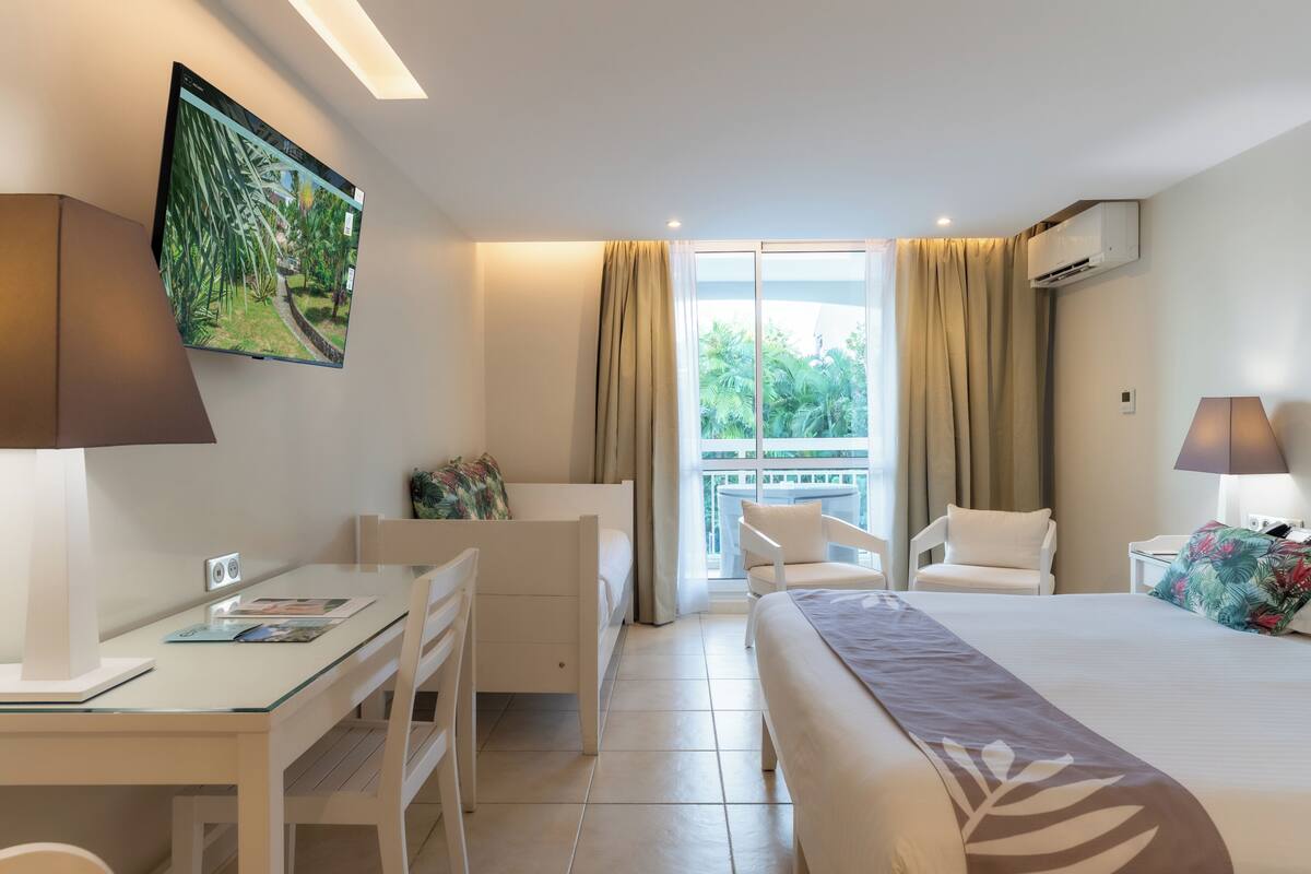 comfort triple room, garden view | premium bedding, in-room safe, laptop workspace, blackout curtains