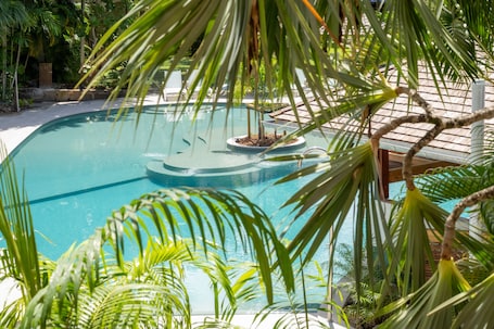 Una piscina al aire libre, sombrillas, sillones reclinables de piscina