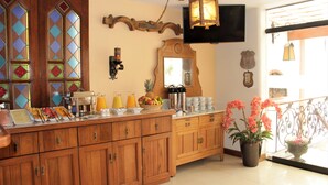A breakfast bar with wooden cabinets, a fruit bowl, and a coffee station. - Hotel El Ducado (Lima)