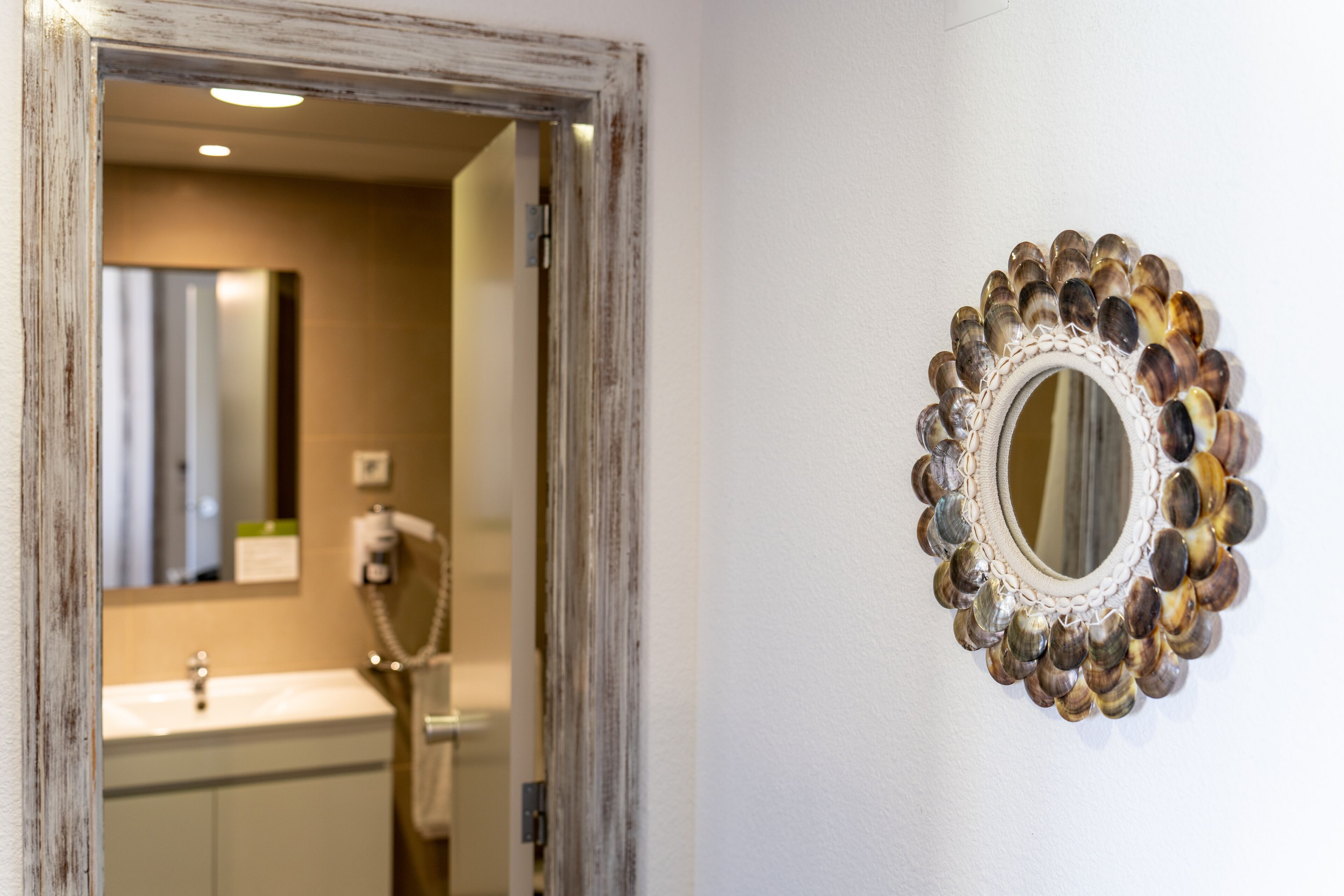 A bathroom with a sink, mirror, and towel rack.