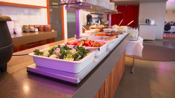 Una mesa de buffet con diversos alimentos y platos.