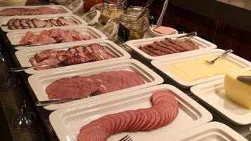 A buffet with various meats and condiments.