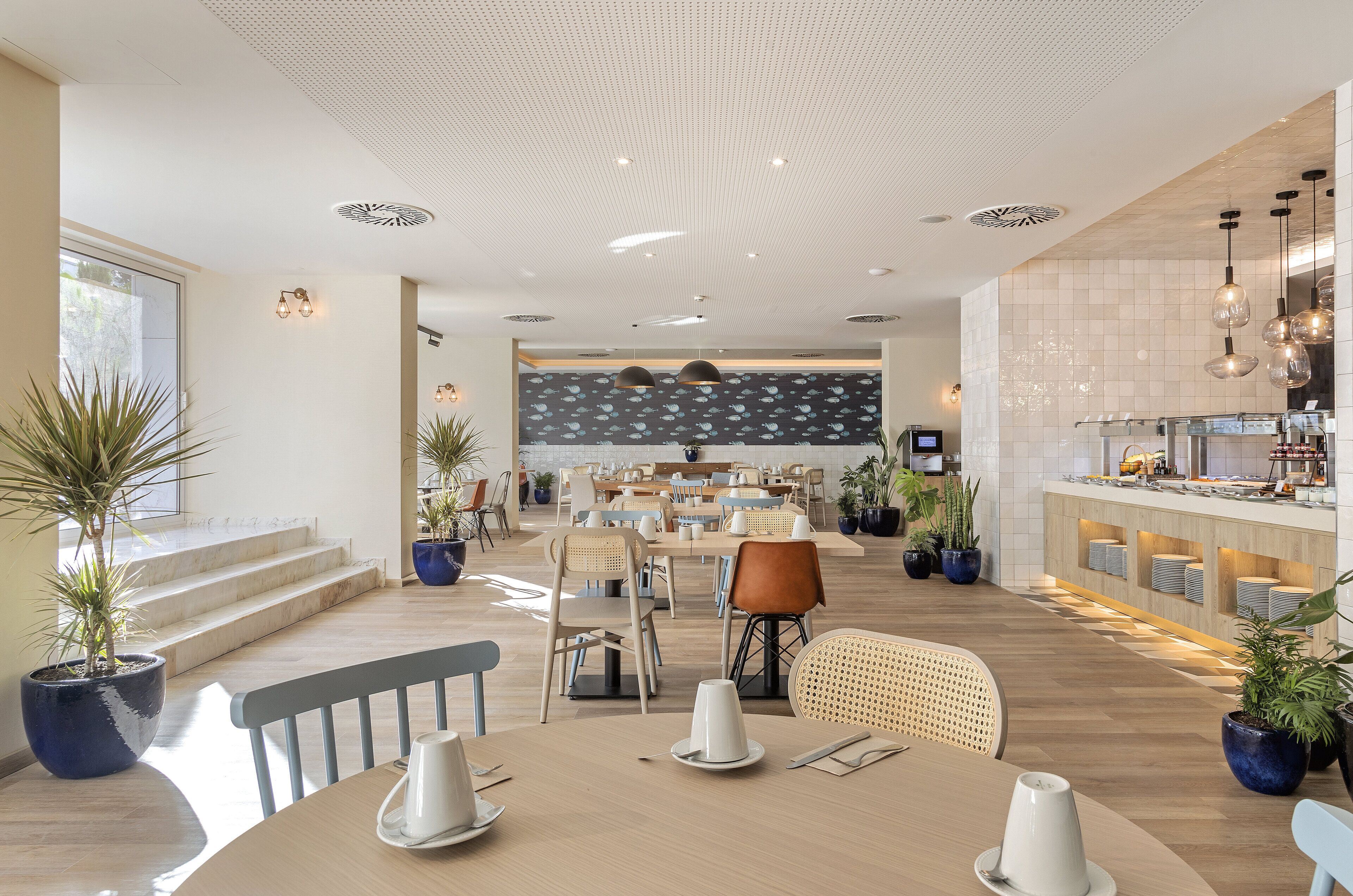 A spacious dining area with high ceilings, modern lighting, and a central seating arrangement.