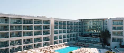 Una piscina cubierta, una piscina al aire libre, sombrillas, tumbonas