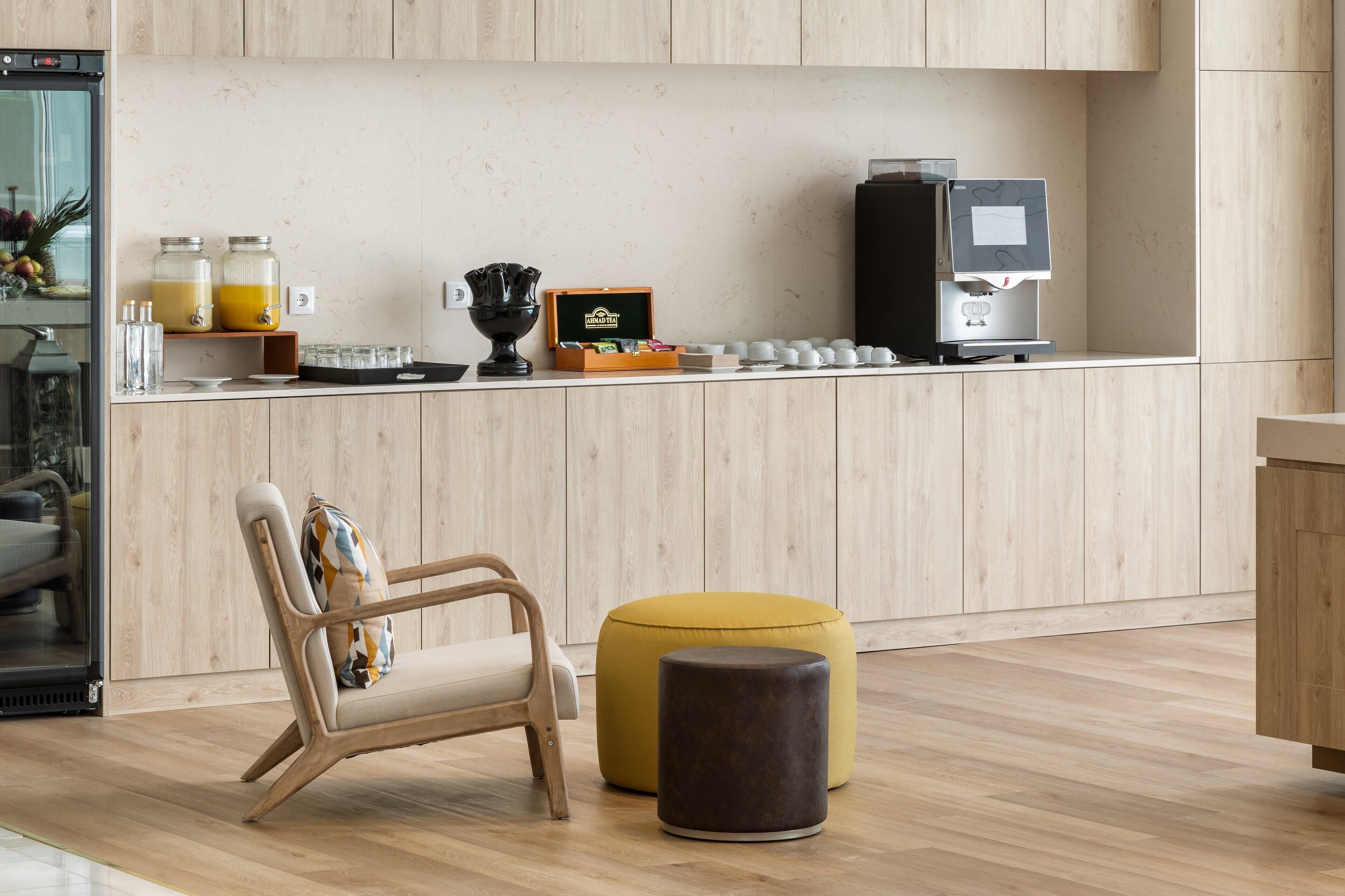 Une cuisine moderne avec des meubles en bois, une machine à café et un panier de fruits.