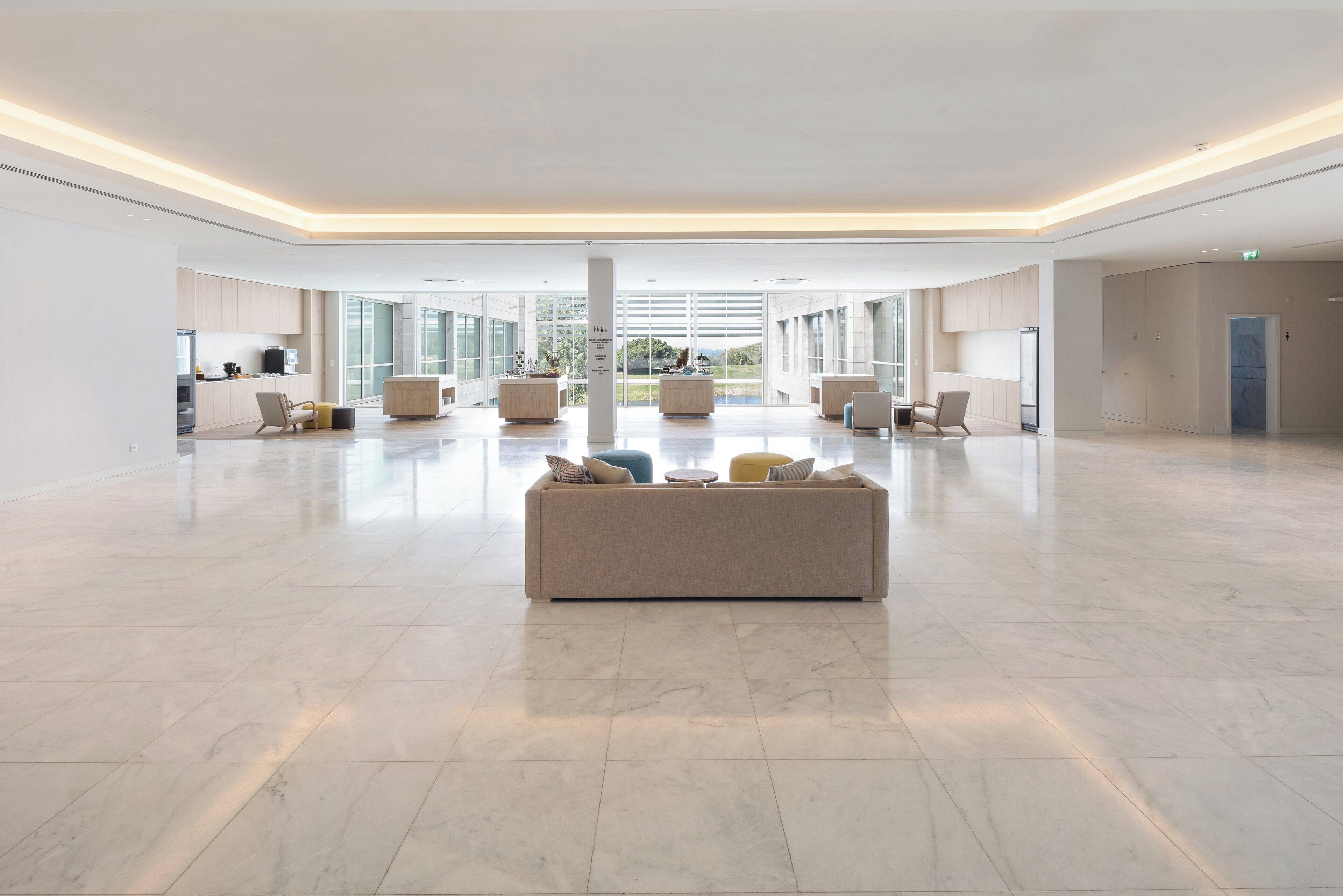 En rummelig lobby med et centralt siddeområde, store vinduer og et moderne design.