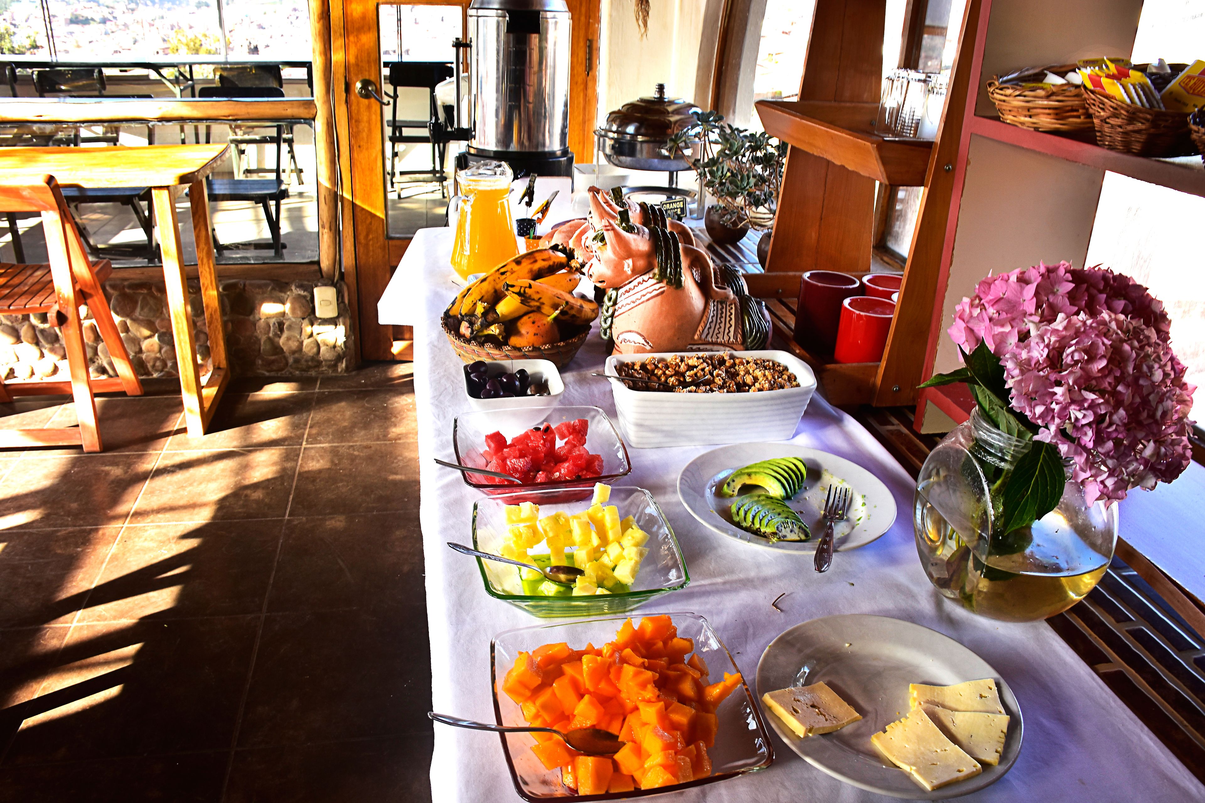 A breakfast buffet with various fruits, vegetables, and cheeses.