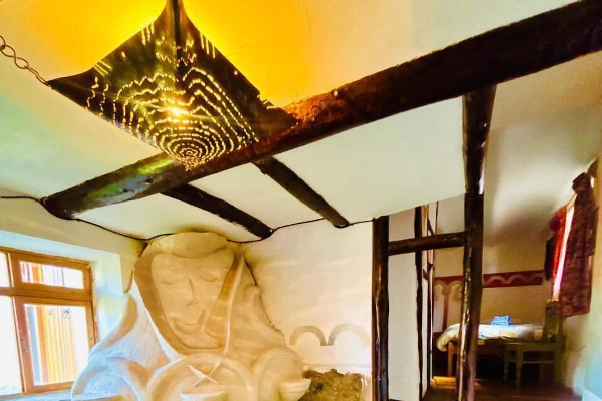 Ein Zimmer mit einer Holztreppe, einem Steinkamin und einem kleinen Tisch mit einem Stuhl.
