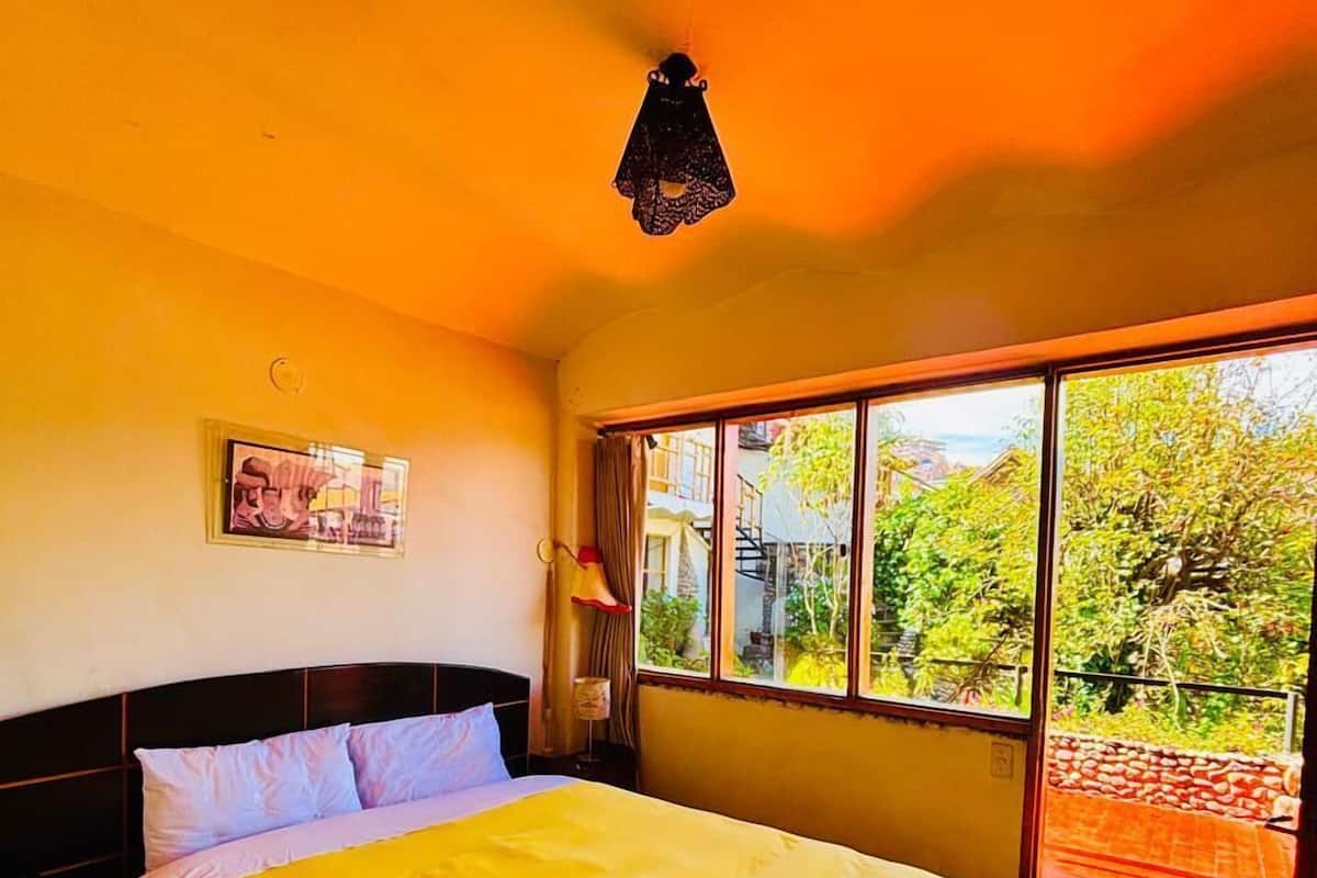Ein Zimmer mit einem Bett, einem Fenster und einem Bild an der Wand.