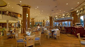 A spacious hotel lobby with wooden flooring, multiple dining areas, and a bar with a nautical theme. - Dreams Vacation Sharm El Sheikh (Sharm El Sheikh)