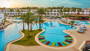 A resort pool area with multiple swimming pools, lounge chairs, and palm trees. - Dreams Vacation Sharm El Sheikh (Sharm El Sheikh)