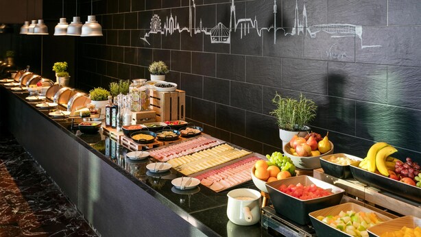 A buffet with various food items and a city skyline mural on the wall. - ARCOTEL Kaiserwasser Vienna (Vienna)