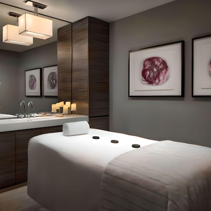 A modern hotel room with a large bed, a vanity with a mirror, and artwork on the walls.