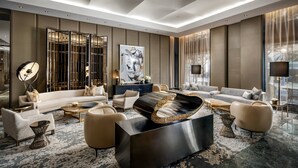 A modern living room with a large sectional sofa, a black coffee table, and a decorative mirror. - The Hazelton Hotel Toronto (Toronto)