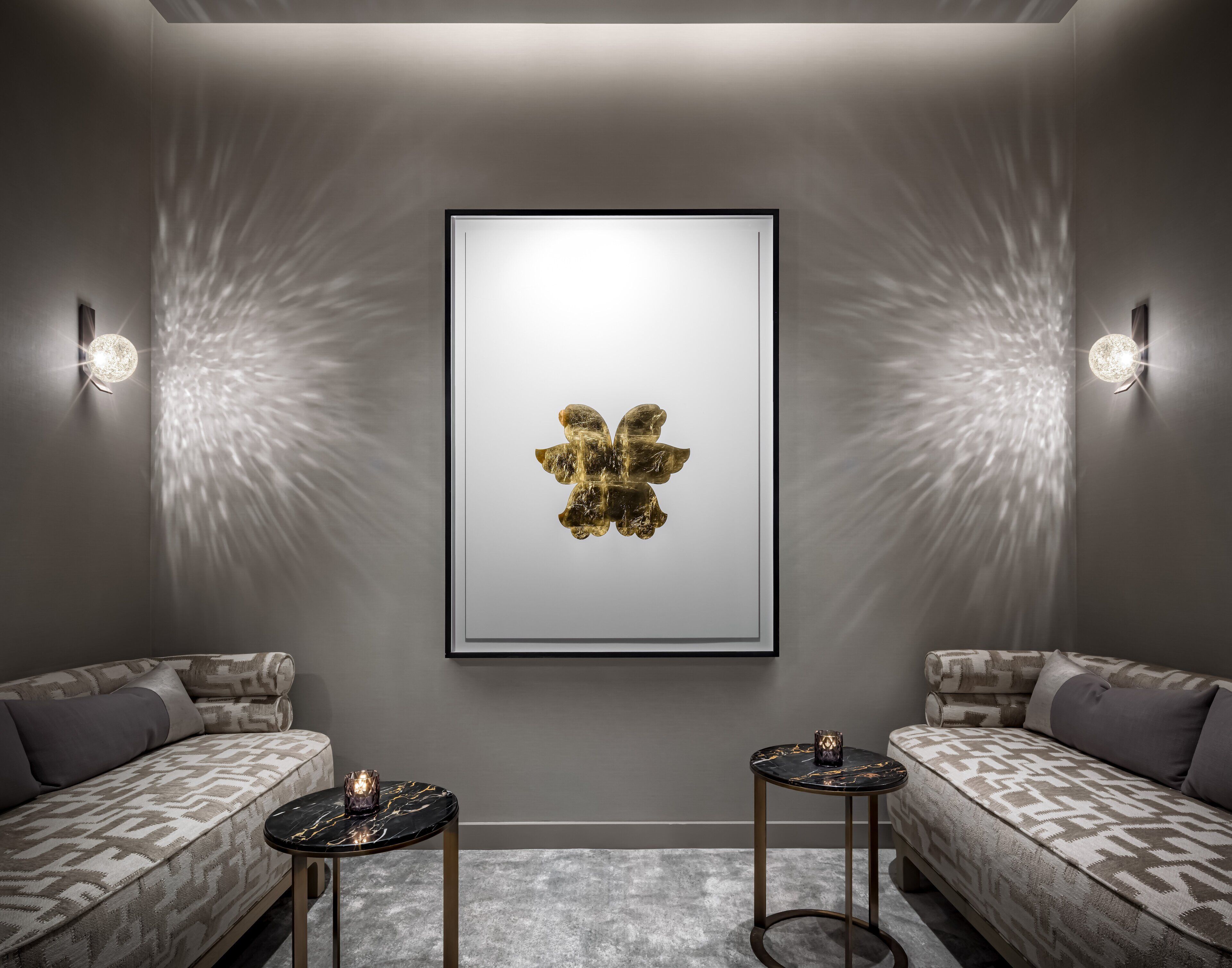 A modern room with a framed artwork, two sofas, and two small tables.
