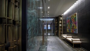 A modern lobby with a marble floor, a seating area with a bench, and a colorful abstract painting on the wall. - The Hazelton Hotel Toronto (Toronto)