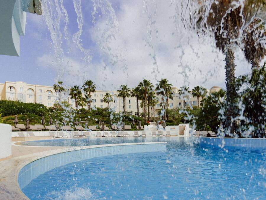 Una piscina al aire libre de temporada, sombrillas