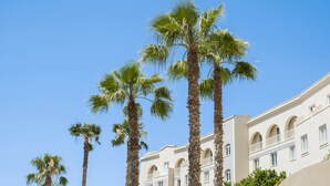 A building with multiple floors, arched windows, and balconies. - Mangia's Selinunte Resort (Castelvetrano)