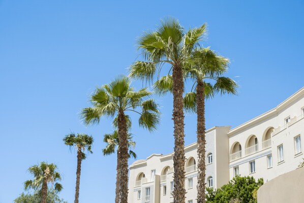 A building with multiple floors, arched windows, and balconies. - Mangia's Selinunte Resort (Castelvetrano)
