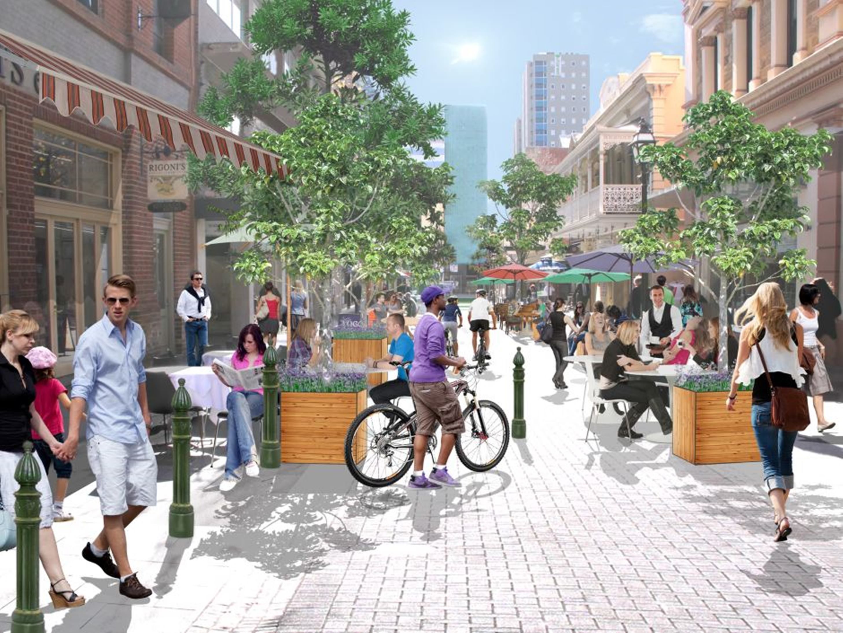 Una animada calle urbana con peatones, ciclistas y terrazas.