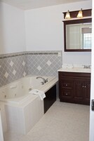 A bathroom with a freestanding bathtub, a vanity with dark wood cabinets, and a mirror above the sink.