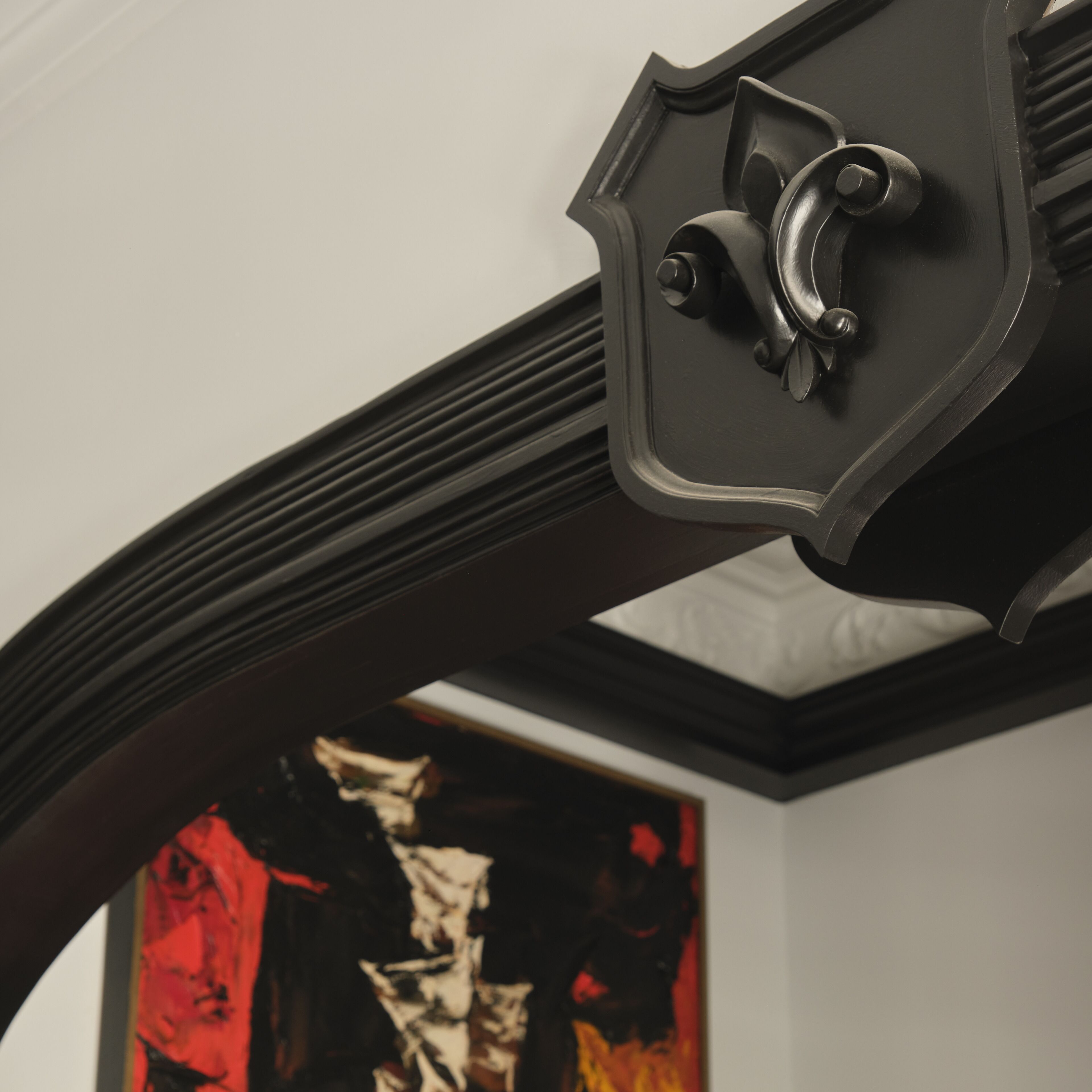 Een plafond met een zwarte, sierlijke, gebogen constructie.
