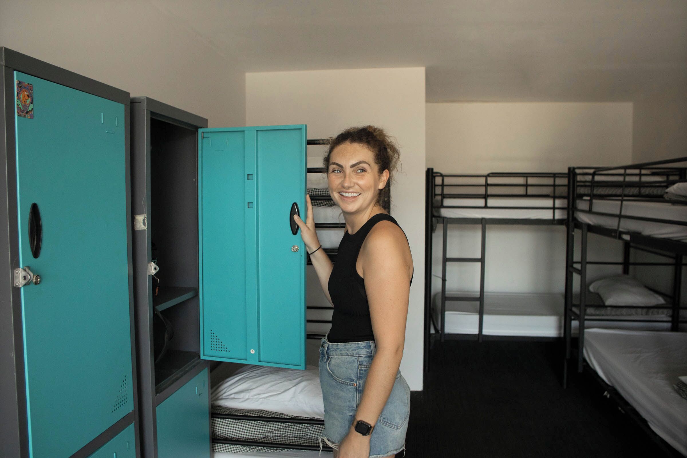 Un dormitorio con literas y un mueble de almacenamiento color turquesa.