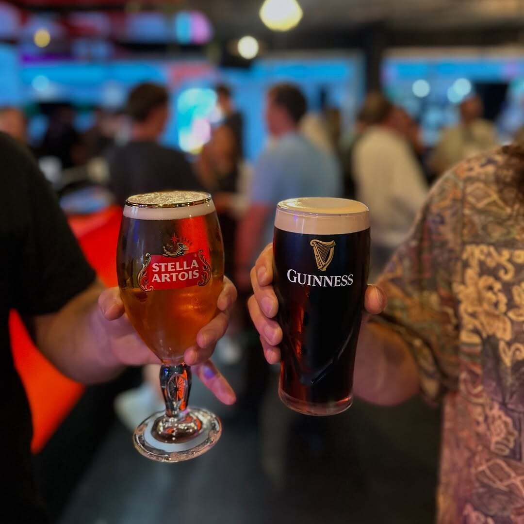 Zwei Personen mit Gläsern Stella Artois und Guinness Bier.