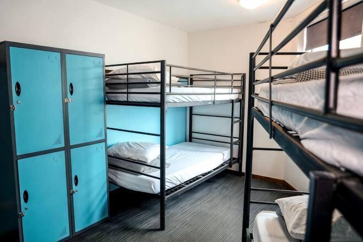 A bunk bed room with a blue wardrobe and a single bed.