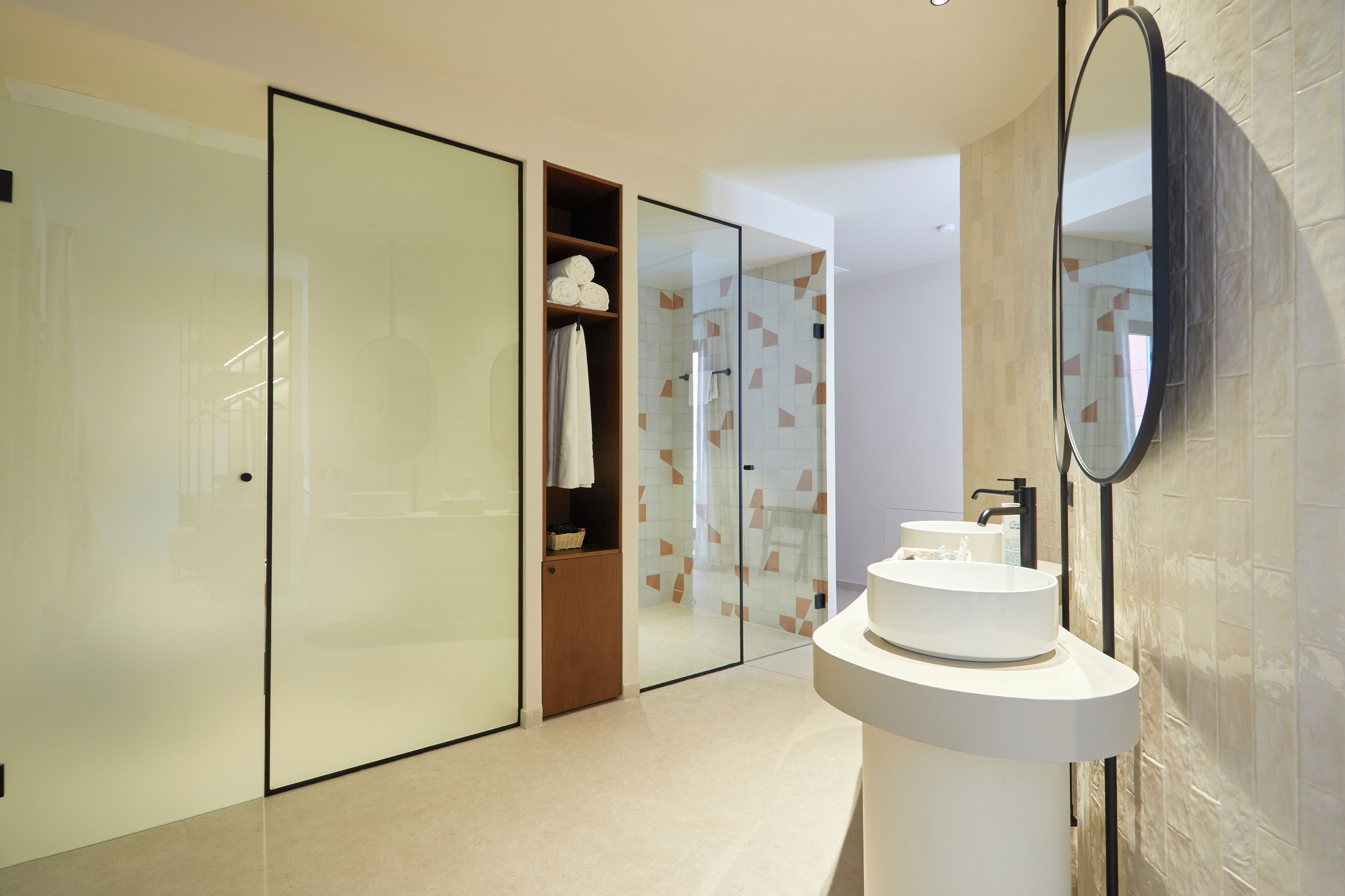 Une salle de bain moderne avec une douche à parois de verre, un meuble-lavabo en bois et un grand miroir.