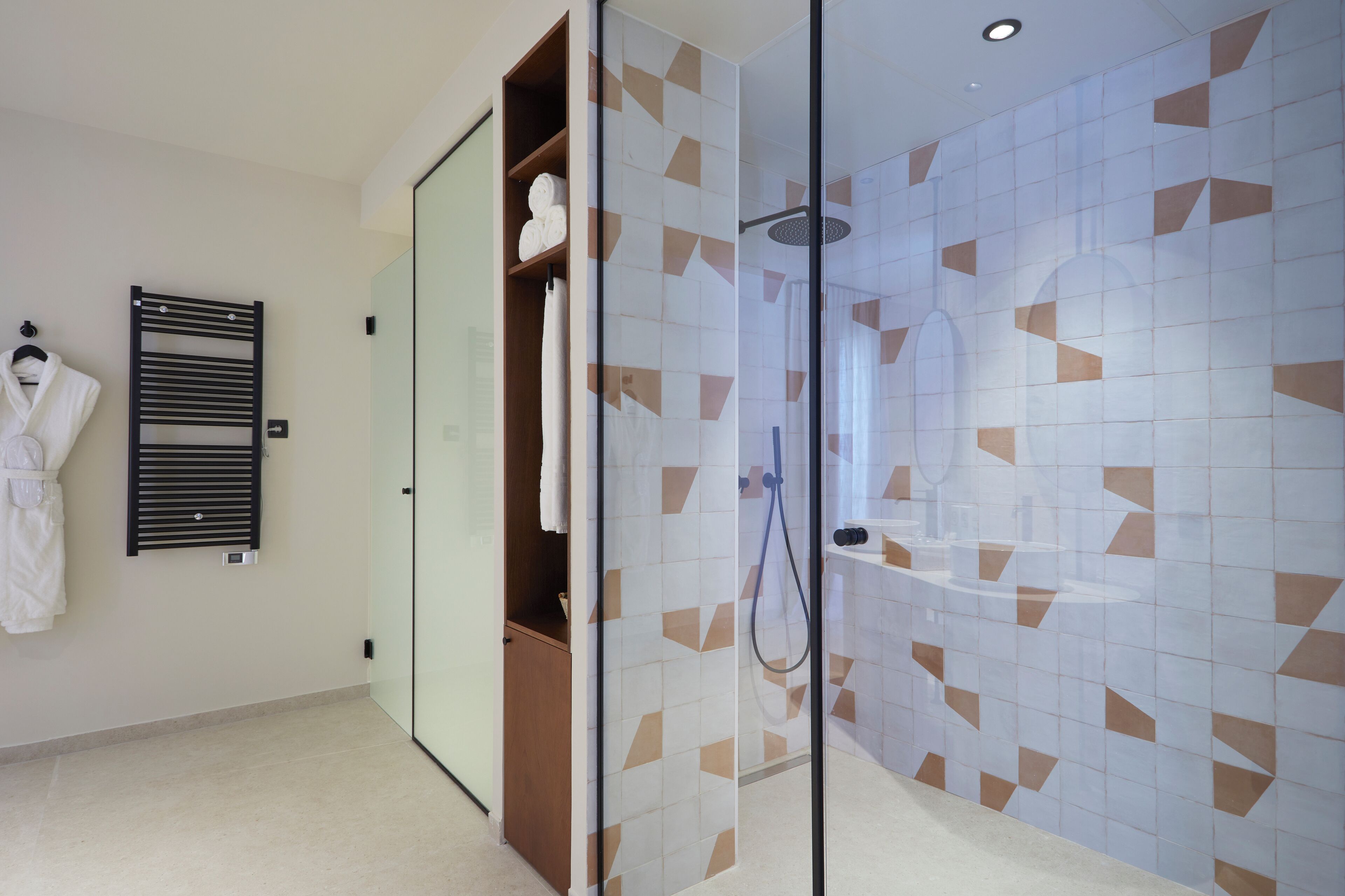 Une salle de bain moderne avec une douche à parois de verre, un porte-serviettes et un meuble en bois.