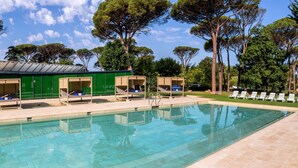 A swimming pool with lounge chairs and sunbeds, surrounded by trees and a covered area with a roof. -  1881 Hotel Balneario Vichy Catalan (Caldes de Malavella)
