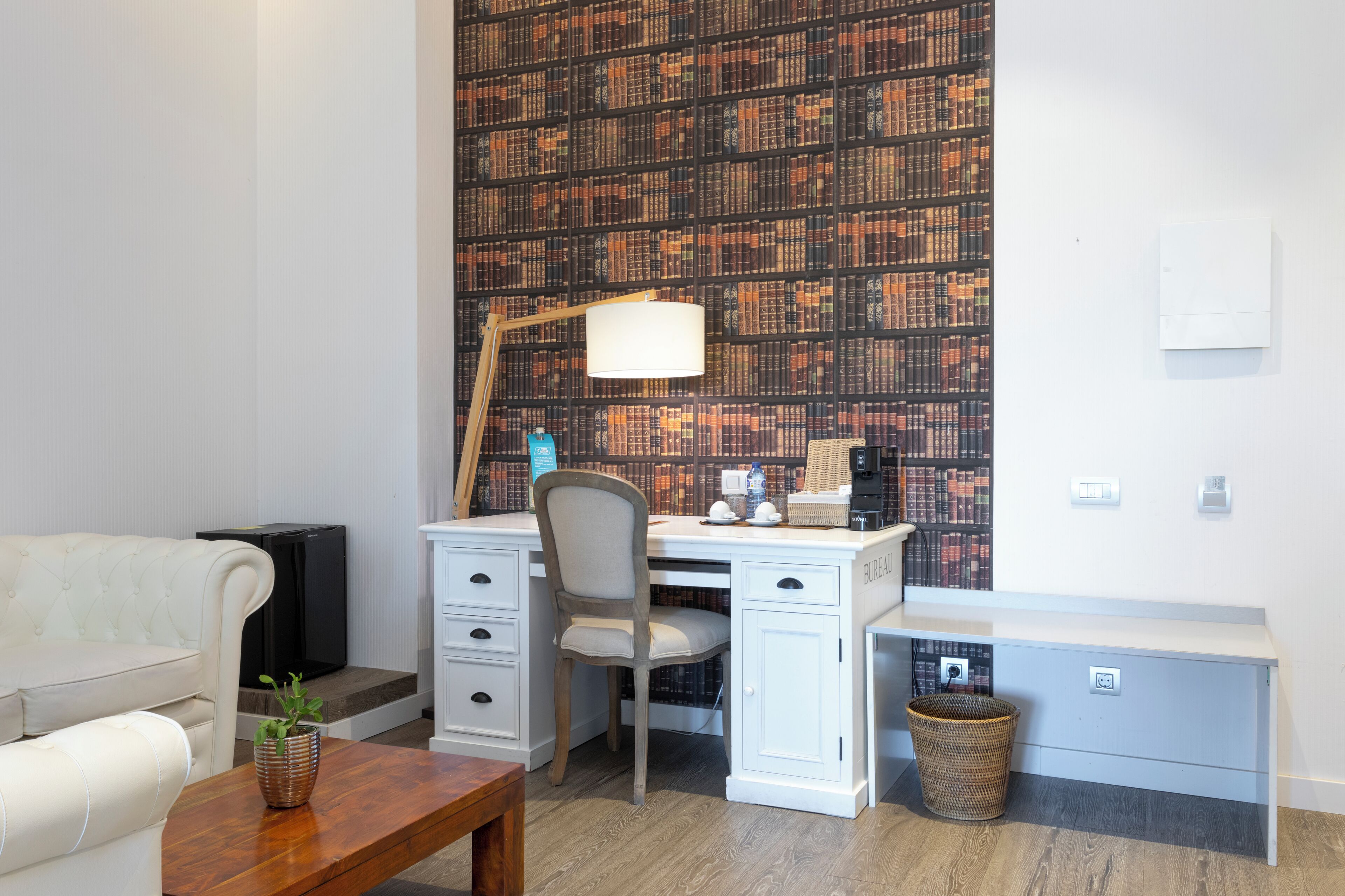 Ein modernes Zimmer mit Schreibtisch, Stuhl und Bücherregal.