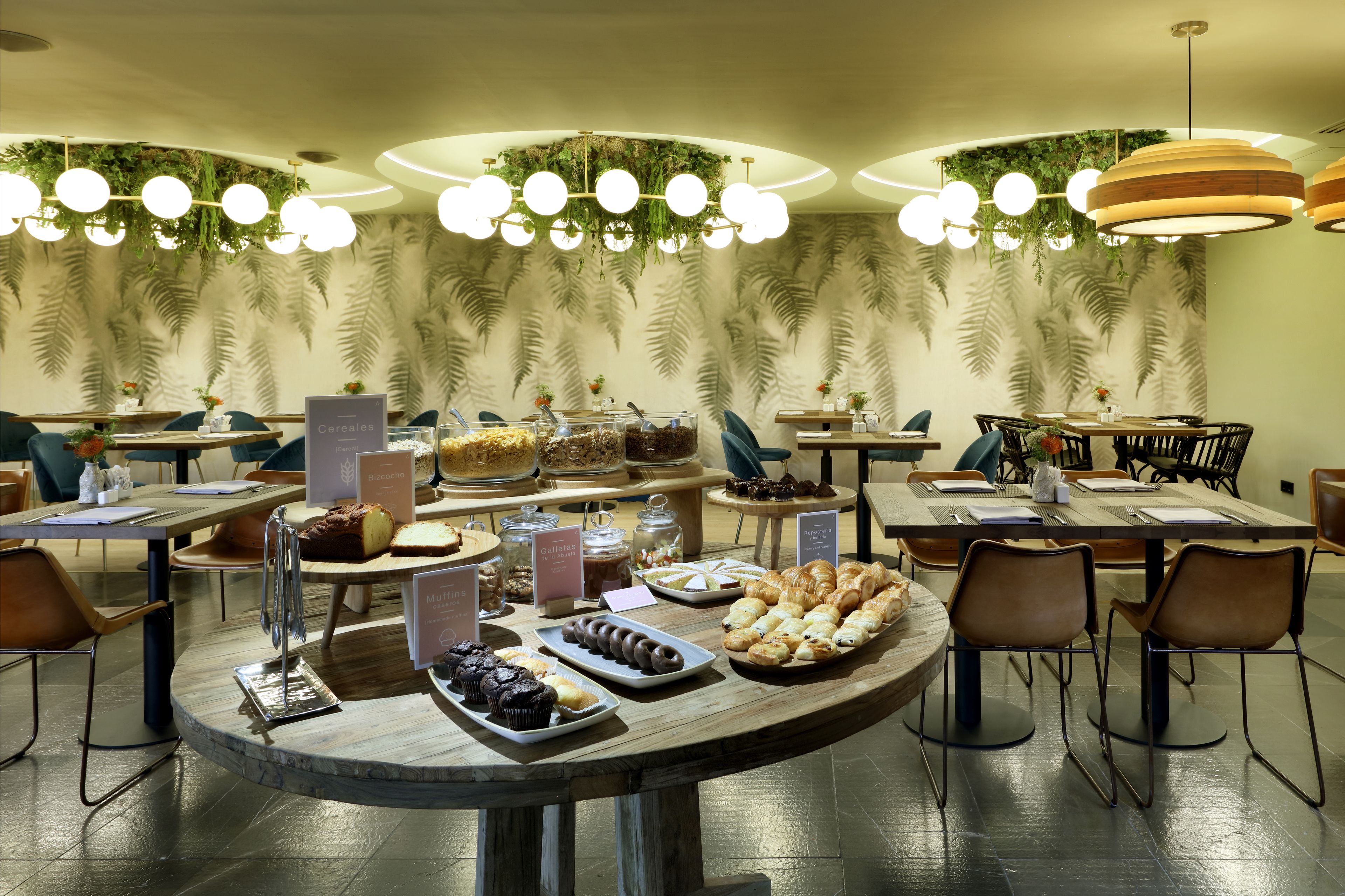 Un bufé de desayuno con diversos pasteles, muffins y cereales.