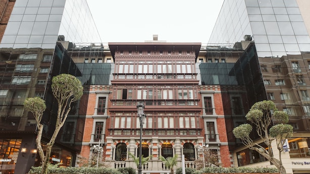 A multi-story building with a traditional facade, large windows, and a central entrance.
