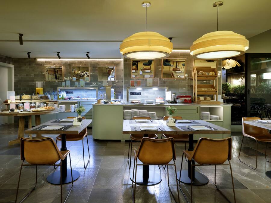 A modern kitchen with a central island, multiple seating arrangements, and pendant lighting.