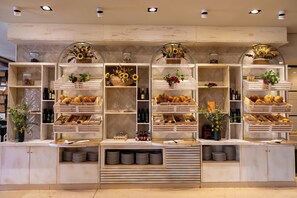 A bakery display with various baked goods and a selection of wine bottles. - Royal Hideaway Sancti Petri (Chiclana de la Frontera)