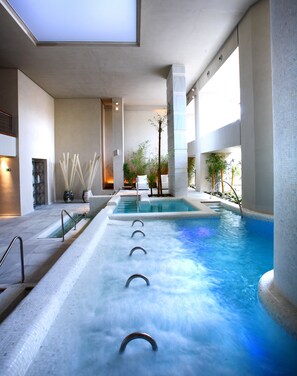 A large indoor swimming pool with multiple lanes, surrounded by modern architecture and indoor plants. - Royal Hideaway Sancti Petri (Chiclana de la Frontera)