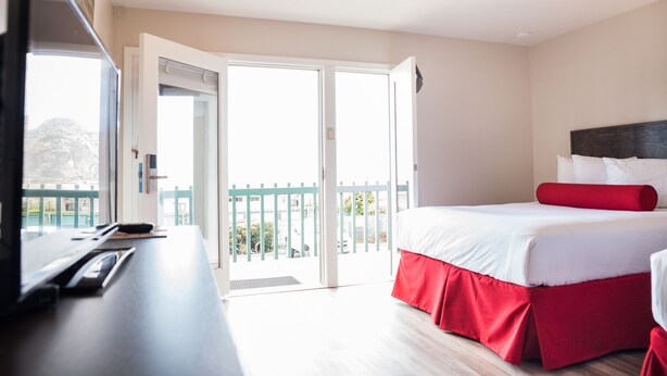 A hotel room with a bed, a desk, and a view of the outdoors. - The Landing at Morro Bay (Morro Bay)