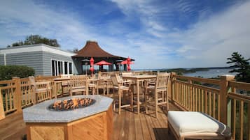 Enjoy a warm gathering by the fire pit on the deck overlooking the serene water view.