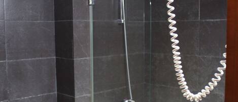 Un baño con bidé, bañera y ducha con cabezal de ducha manual.