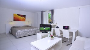 Une chambre d’hôtel moderne équipée d’un lit, d’une télévision, d’un bureau et d’un canapé.