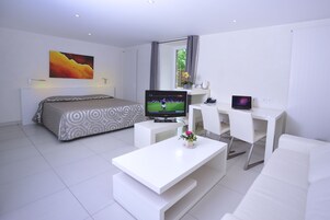 Una habitación de hotel moderna con cama, televisión, escritorio y sofá.