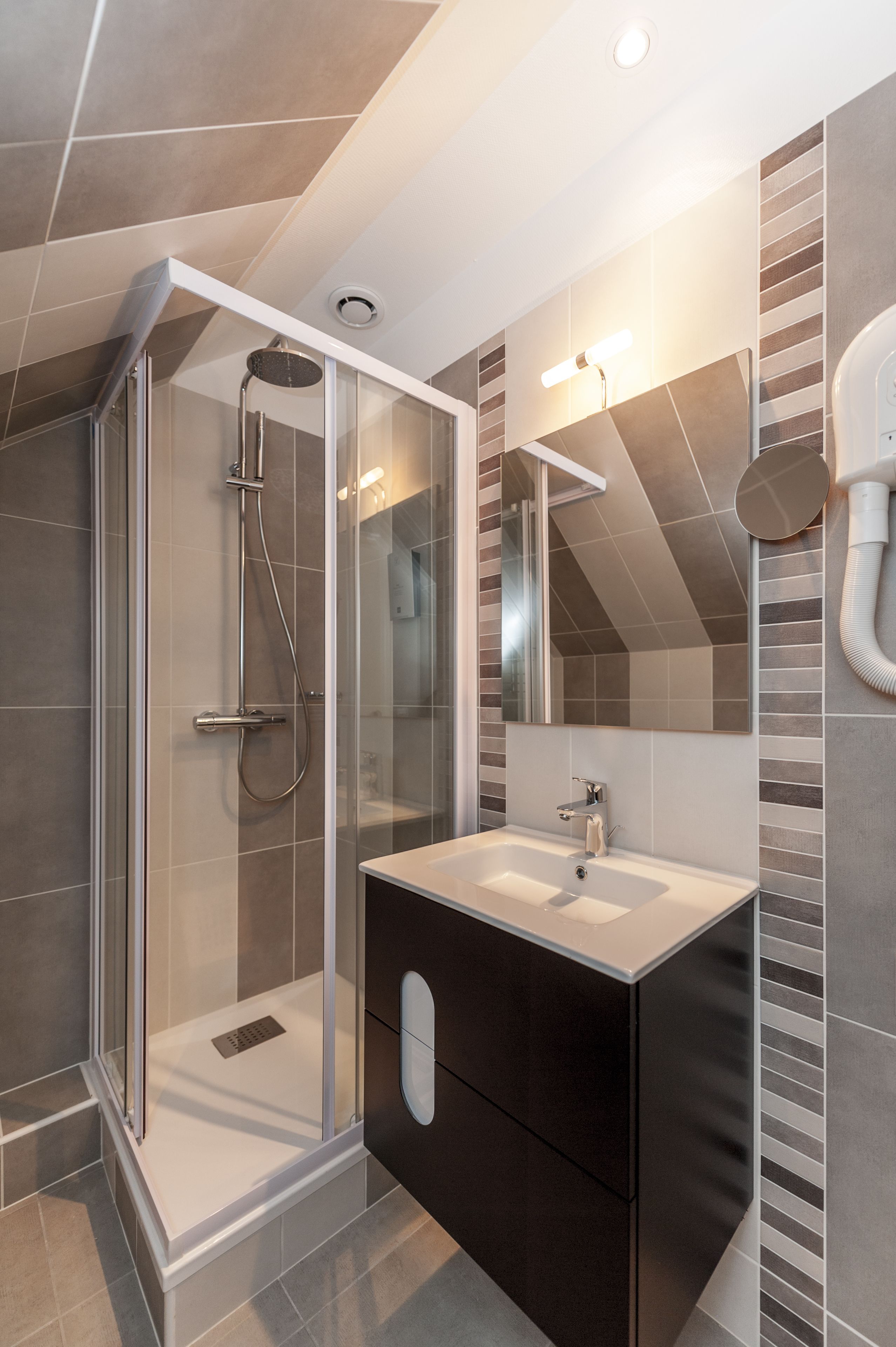 A modern bathroom with a glass-enclosed shower, a sink, and a vanity.