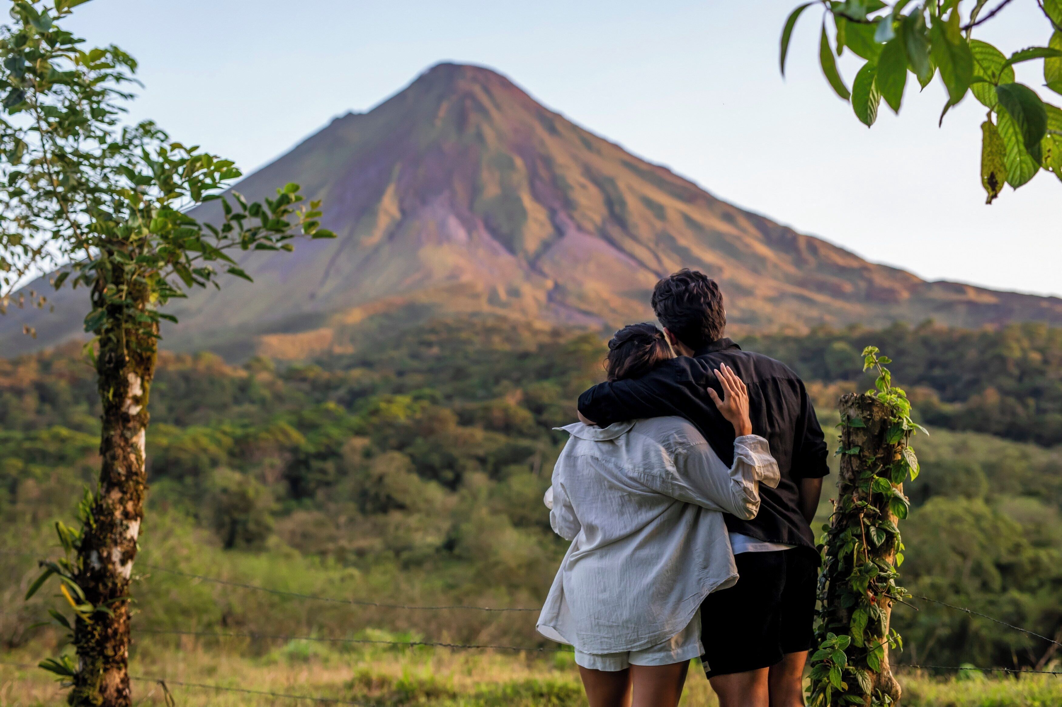 A couple embracing with a mountain in the background.